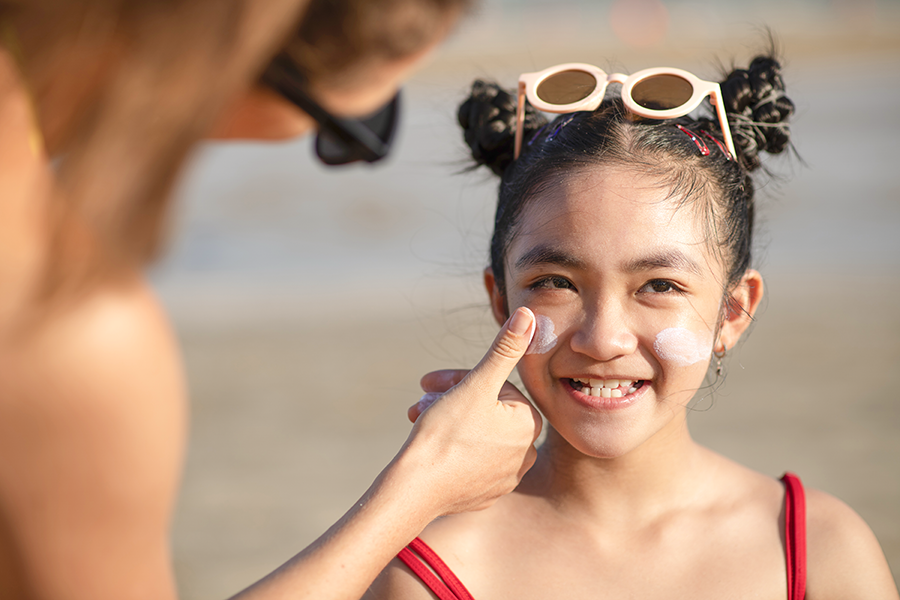 Person applying sunscreen on a child's face