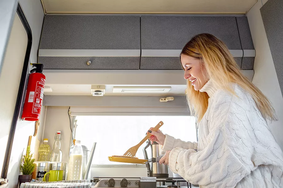 A woman cooking in her campervan