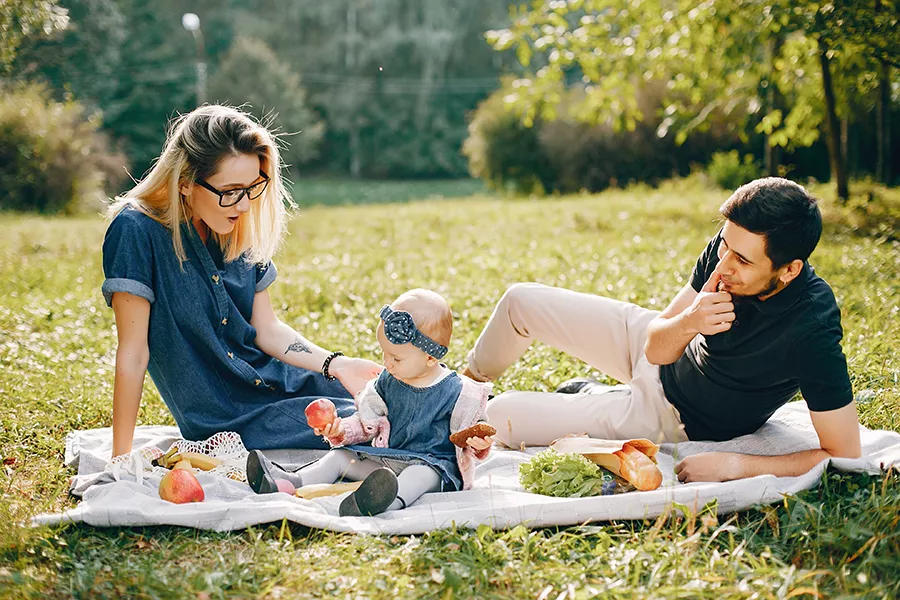 A family with a baby having a picnic in a park