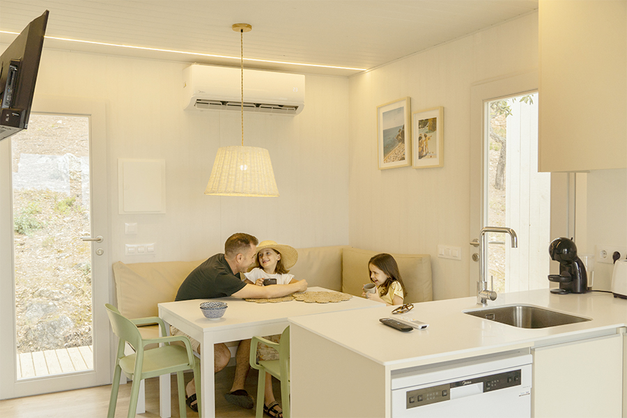 Padre e figlie nella sala da pranzo del loro bungalow in vacanza