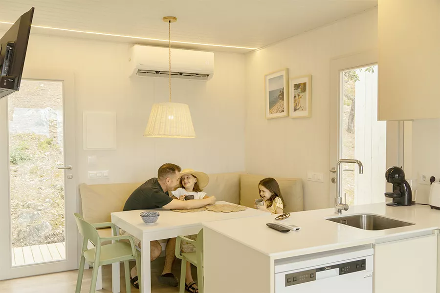 Father and his daughters in the living room of their holiday bungalow