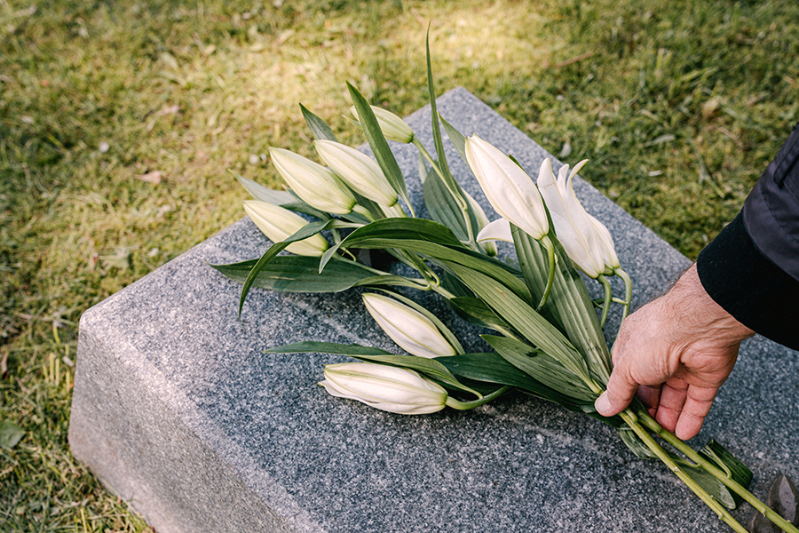 Famiglia che lascia fiori su una tomba per Ognissanti