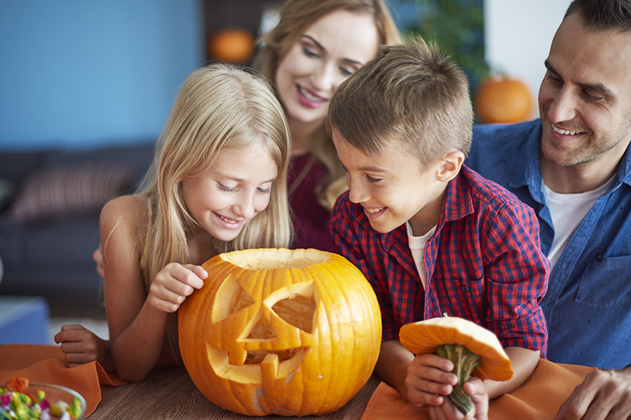 Famiglia che decora zucche per Halloween