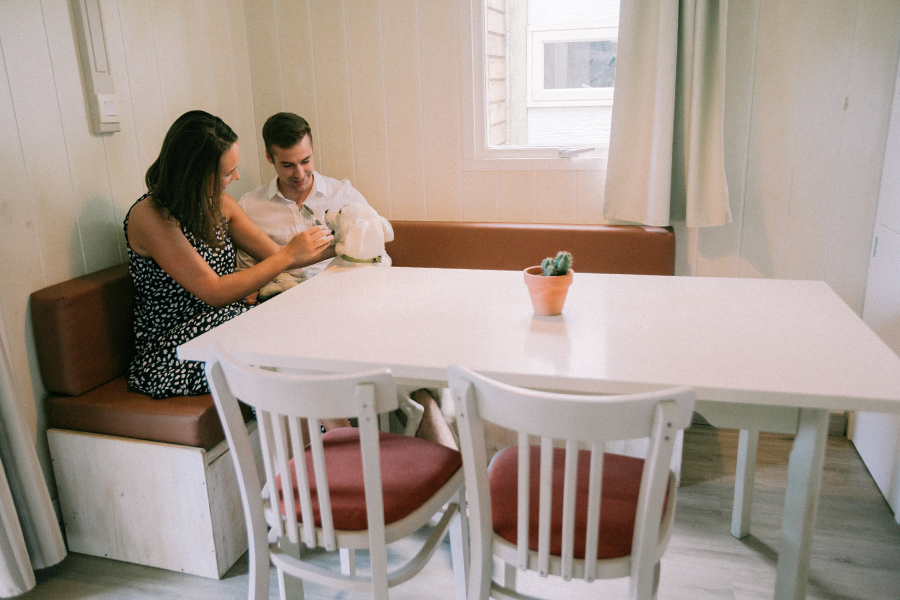 Couple with their dog in the living room of their mobile home on holidays