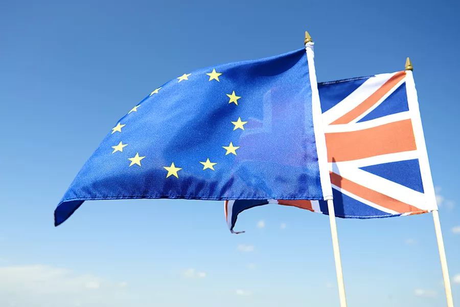 Flags of the European Union and the United Kingdom together over blue sky