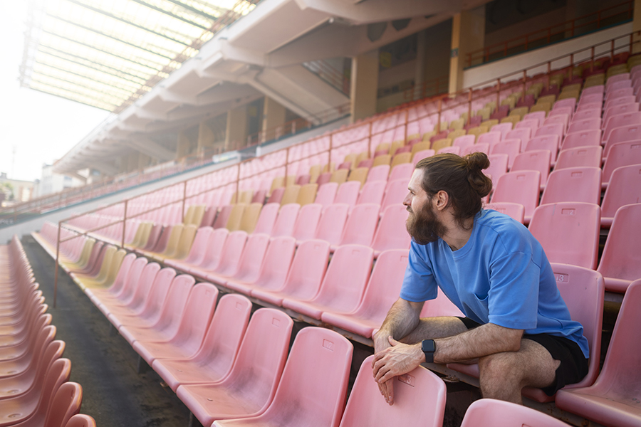 Man sitting in a stadium seat.