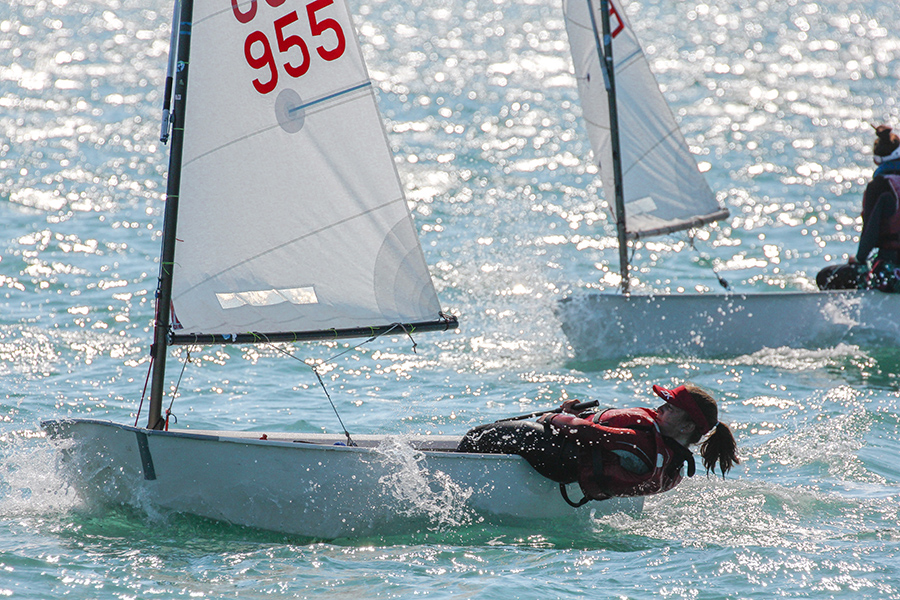 Woman in an Optimist dinghy.